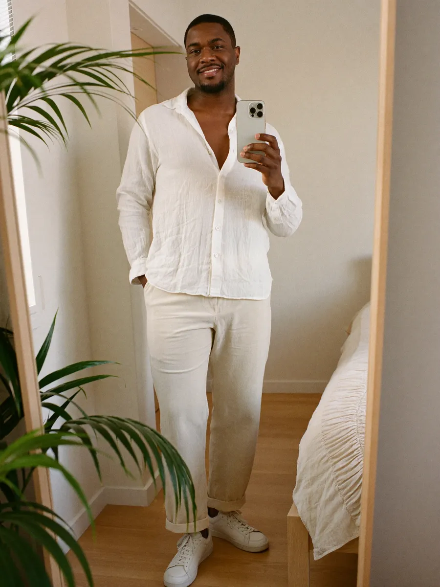A man checking his outfit in a full-length mirror